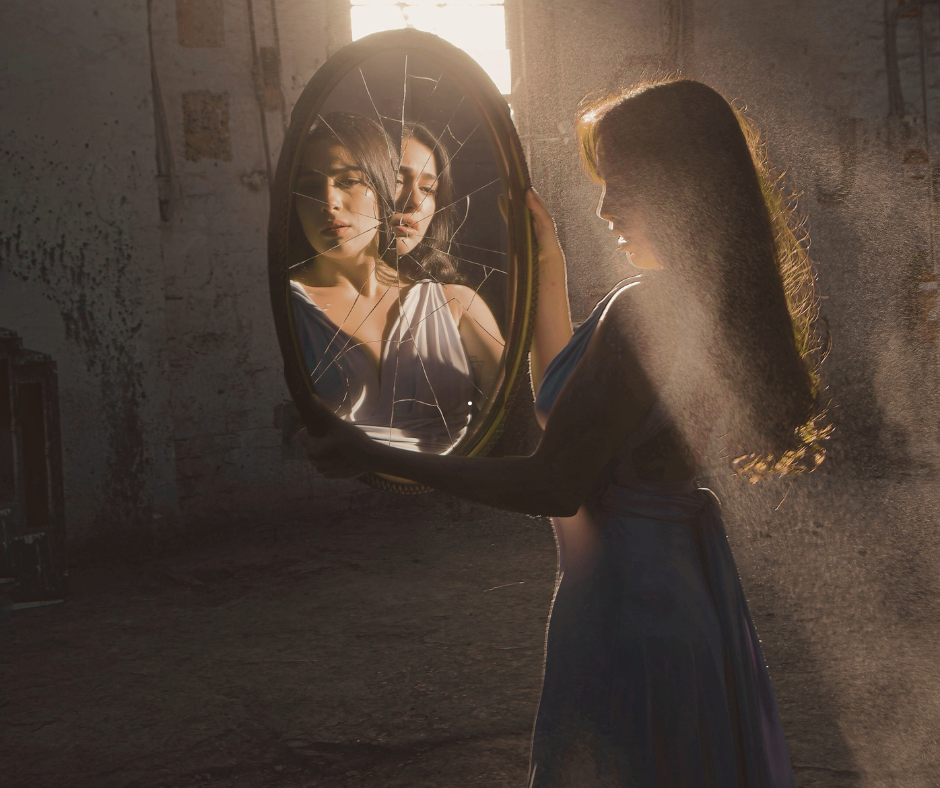 Woman holding a cracked mirror, symbolising self-judgment and hidden shame in high achievers.